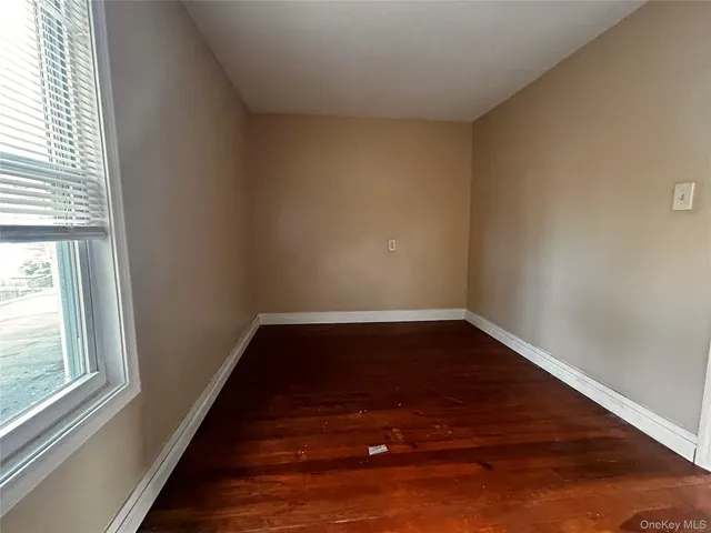 a view of a room with wooden floor and window