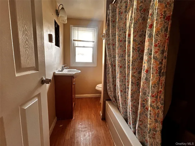 a view of a bathroom with a sink and wooden floor