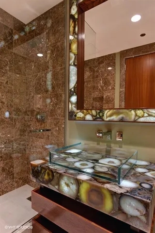 a bathroom with a granite countertop sink a toilet and shower