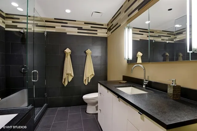 a bathroom with a sink vanity mirror and toilet