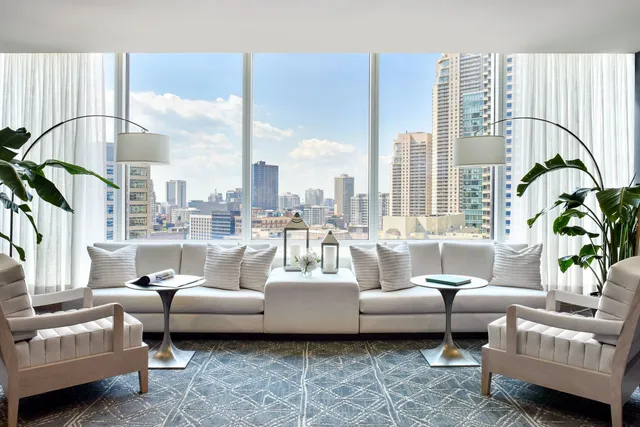 a living room with furniture and floor to ceiling windows
