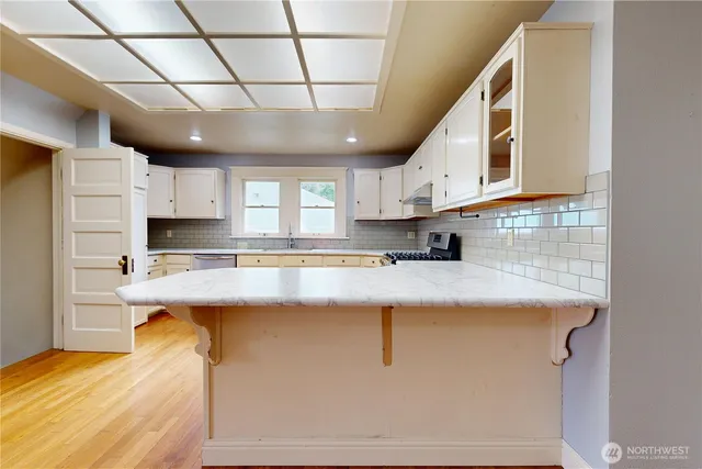 a kitchen with stainless steel appliances granite countertop a sink a stove and cabinets
