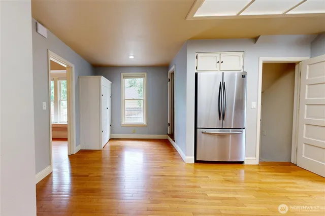 a view of a kitchen with a refrigerator and wooden floor