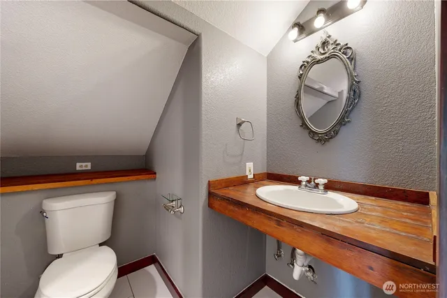 a bathroom with a toilet sink and mirror
