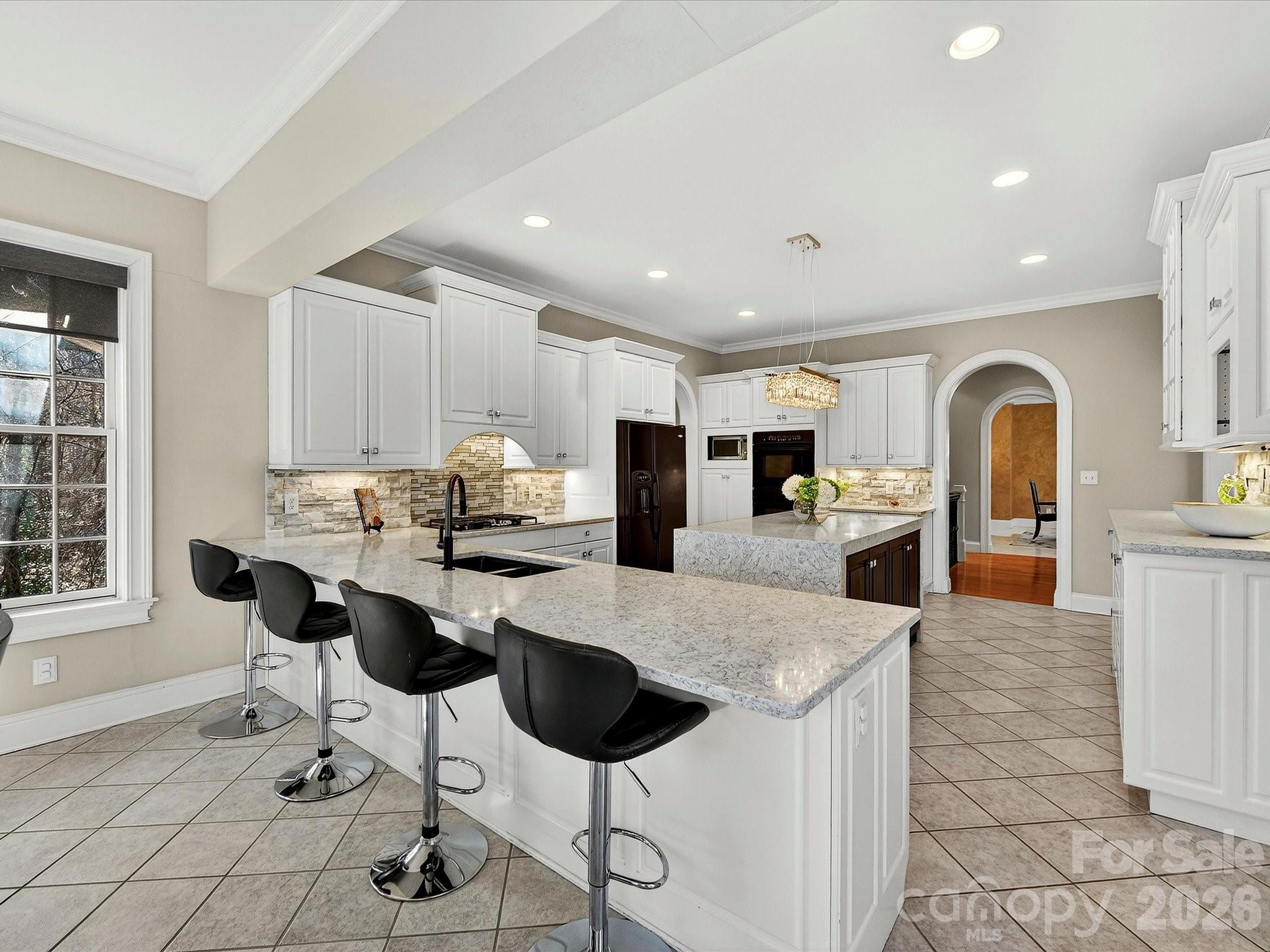 1779 8th St Drive Northwest Hickory, NC 28601 - Photo 12 of 36 a kitchen with stainless steel appliances granite countertop a stove top oven a sink a dining table and chairs with wooden floor