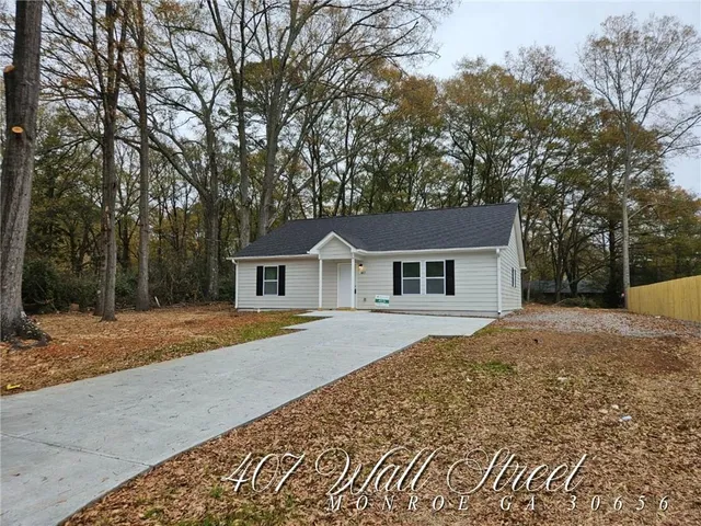 a front view of a house with a yard and trees
