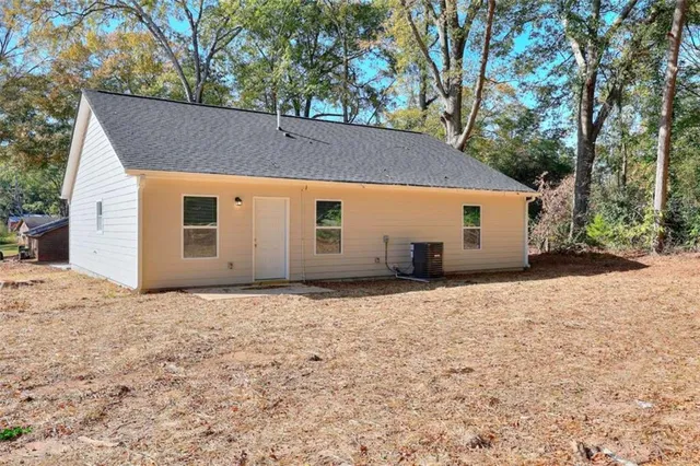 a backyard of house with garage and trees