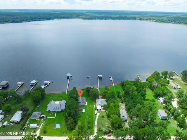 a backyard of a house with lots of green space and lake view