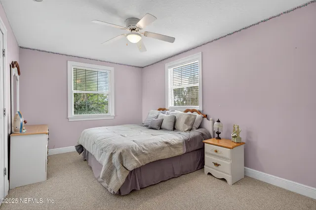 a spacious bedroom with a bed and a chandelier