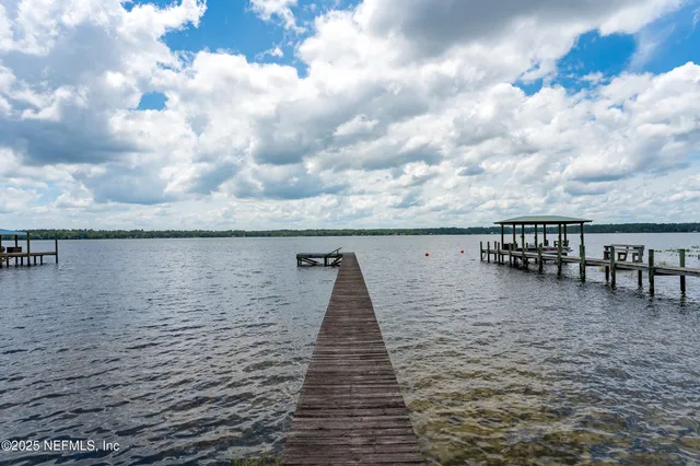 a view of a tennis ground with large trees