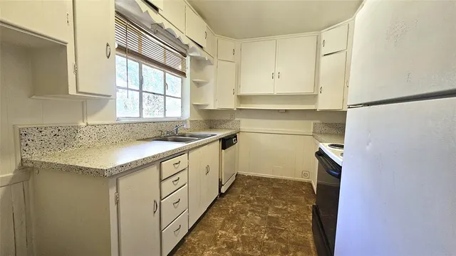 a kitchen with granite countertop a sink and cabinets