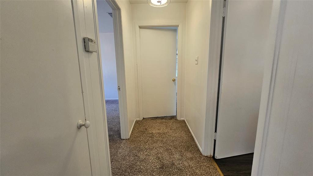2621 North Locust Street Denton, TX 76209 - Photo 13 of 26 a view of a hallway with wooden floor and a bathroom