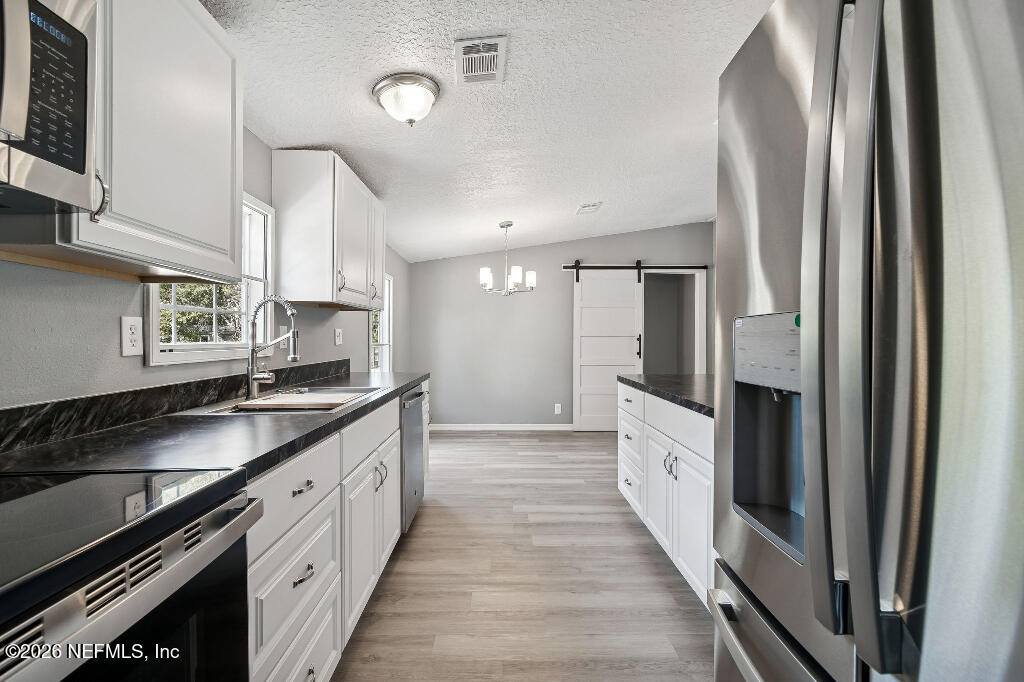 101 Ridgewood Avenue Interlachen, FL 32148 - Photo 11 of 25 a large kitchen with a large counter top space a sink stainless steel appliances and cabinets