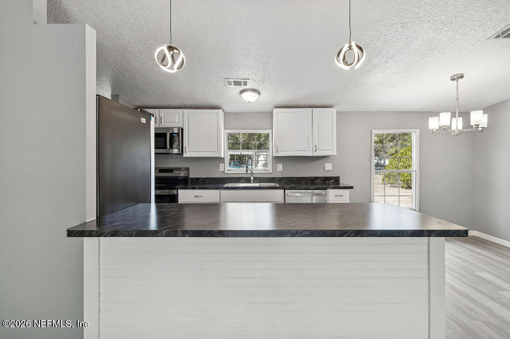 101 Ridgewood Avenue Interlachen, FL 32148 - Photo 13 of 25 a large kitchen with granite countertop a refrigerator a sink a stove a dining table and chairs