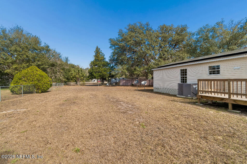 101 Ridgewood Avenue Interlachen, FL 32148 - Photo 22 of 25 a backyard of a house with wooden fence and trees