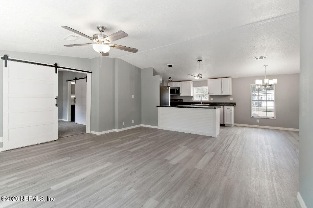 101 Ridgewood Avenue Interlachen, FL 32148 - Photo 4 of 25 a view of a kitchen with a sink a ceiling fan and wooden floor