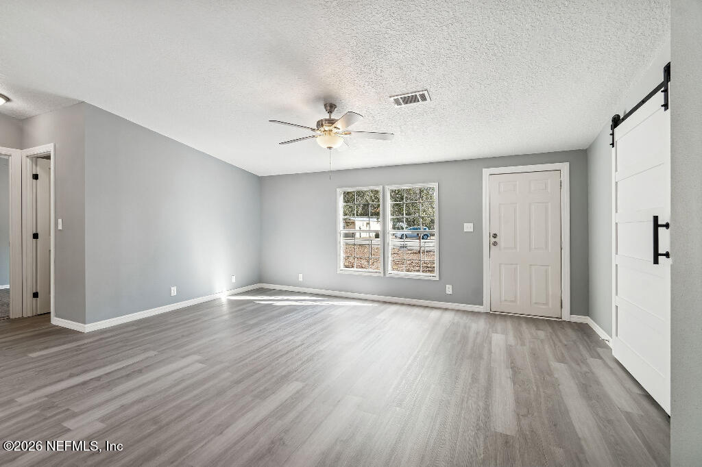 101 Ridgewood Avenue Interlachen, FL 32148 - Photo 5 of 25 a view of an empty room with wooden floor and a window