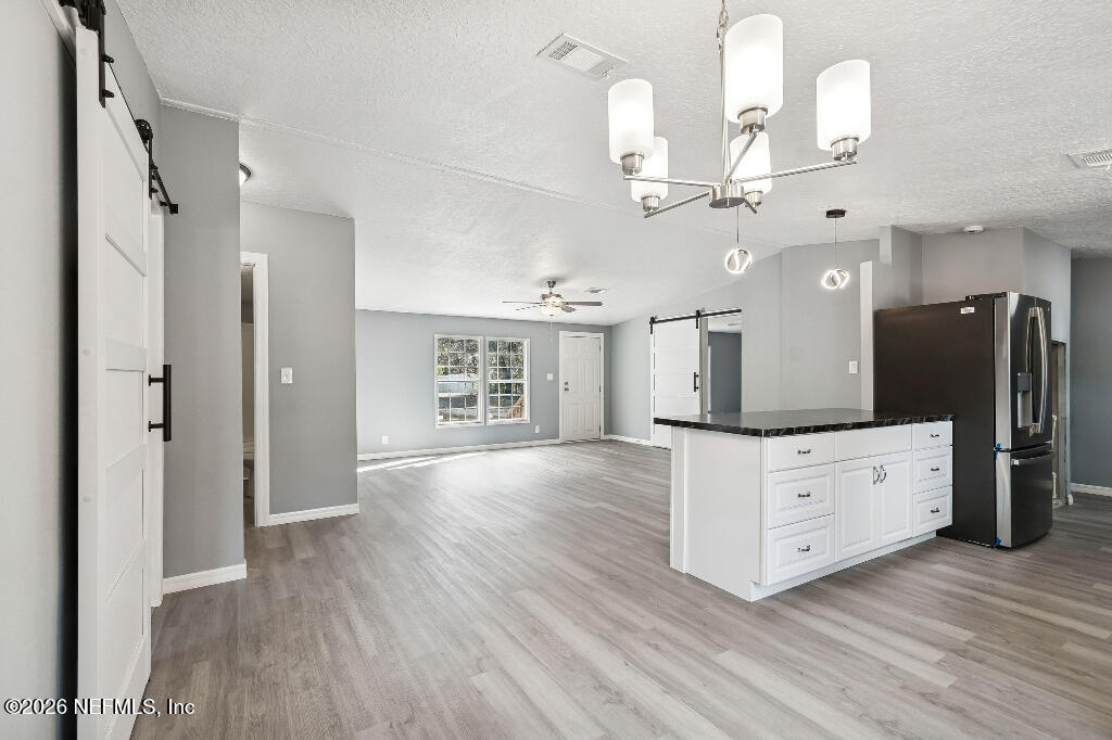 101 Ridgewood Avenue Interlachen, FL 32148 - Photo 8 of 25 wooden floor with white cabinets and chandelier