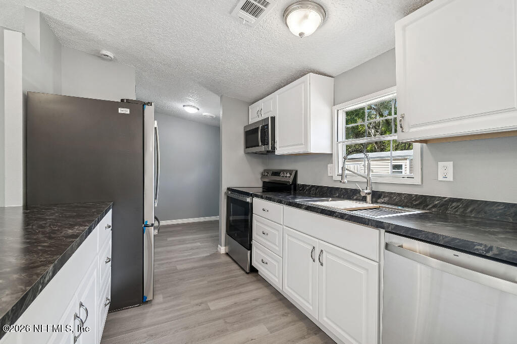 101 Ridgewood Avenue Interlachen, FL 32148 - Photo 10 of 25 a kitchen with granite countertop a sink stove and cabinets