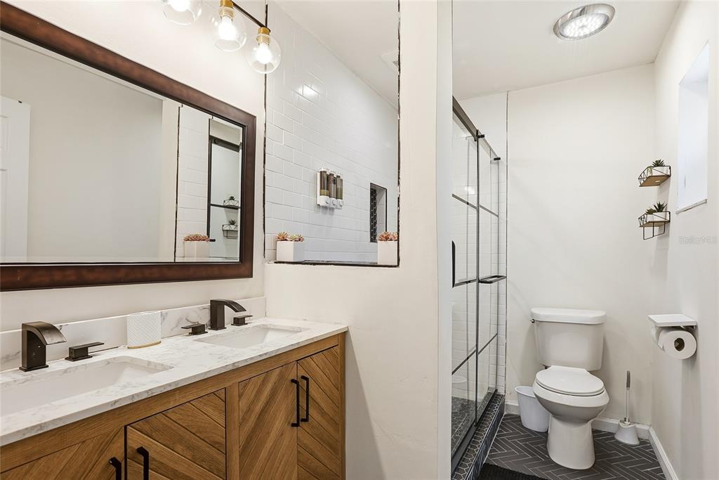 4606 Buckeye Road Tampa, FL 33624 - Photo 27 of 39 a bathroom with a granite countertop sink mirror vanity and toilet