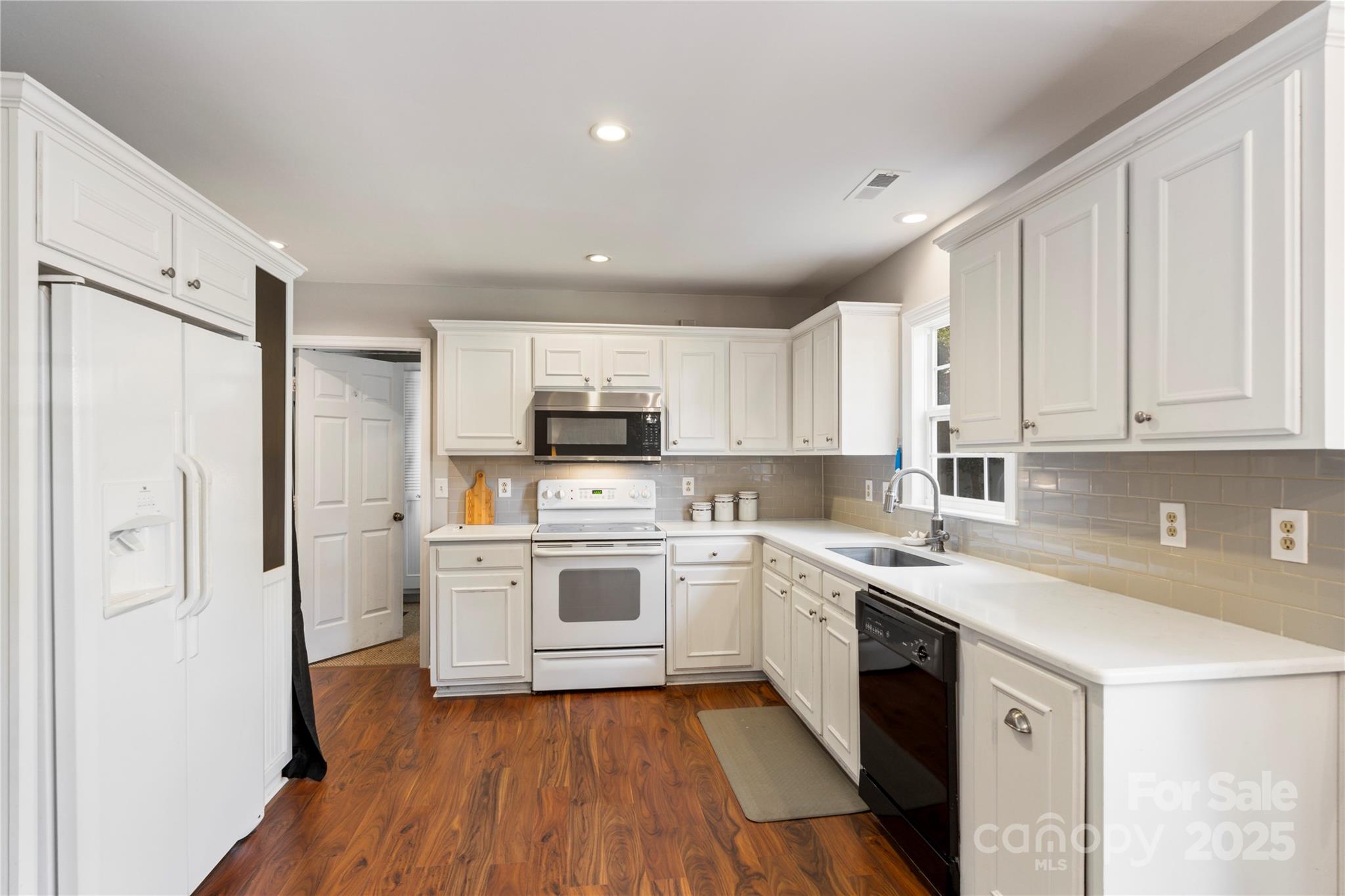 2519 Fitzpatrick Lane Matthews, NC 28105 - Photo 12 of 46 a kitchen with white cabinets stainless steel appliances and sink