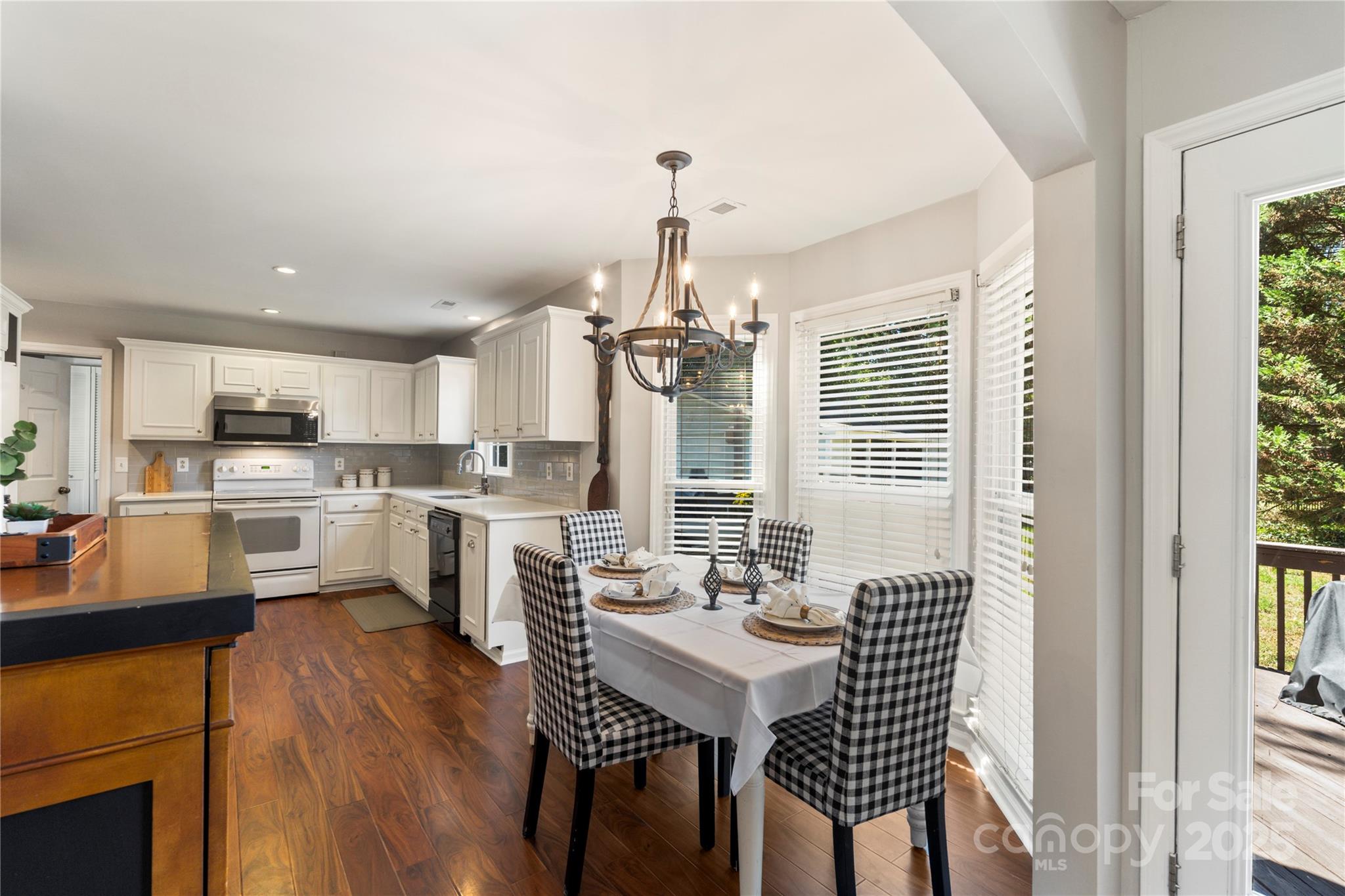 2519 Fitzpatrick Lane Matthews, NC 28105 - Photo 17 of 46 a kitchen with a table chairs wooden floors and view living room