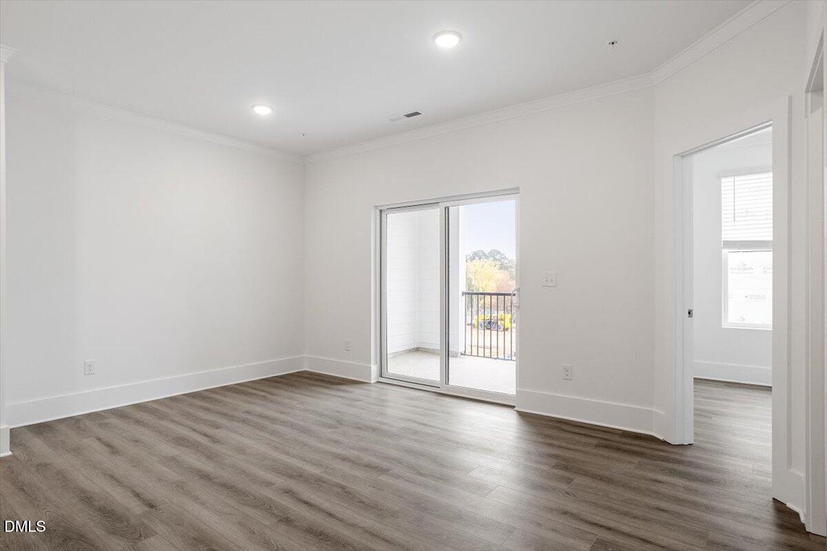 509 Kildaire Farm Road, Unit 302 Cary, NC 27511 - Photo 13 of 30 a view of an empty room with wooden floor and a window