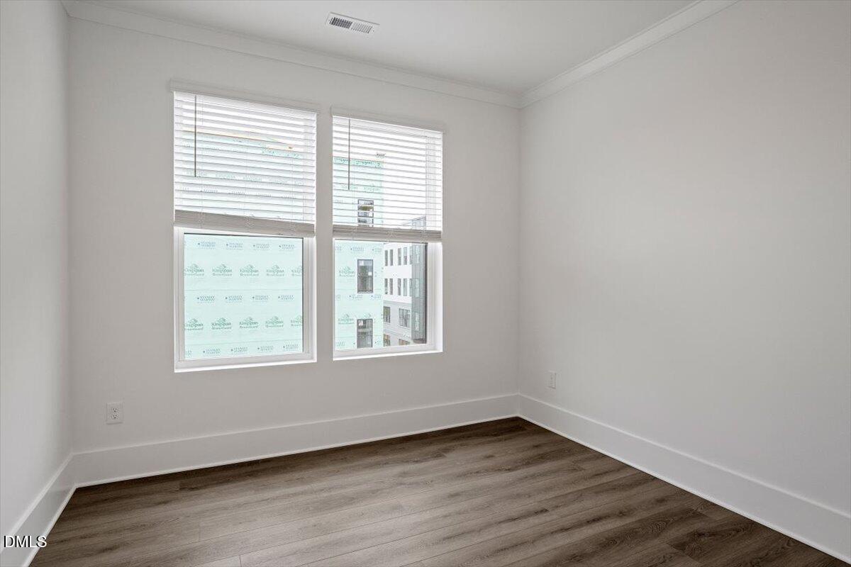 509 Kildaire Farm Road, Unit 302 Cary, NC 27511 - Photo 15 of 30 an empty room with wooden floor and windows