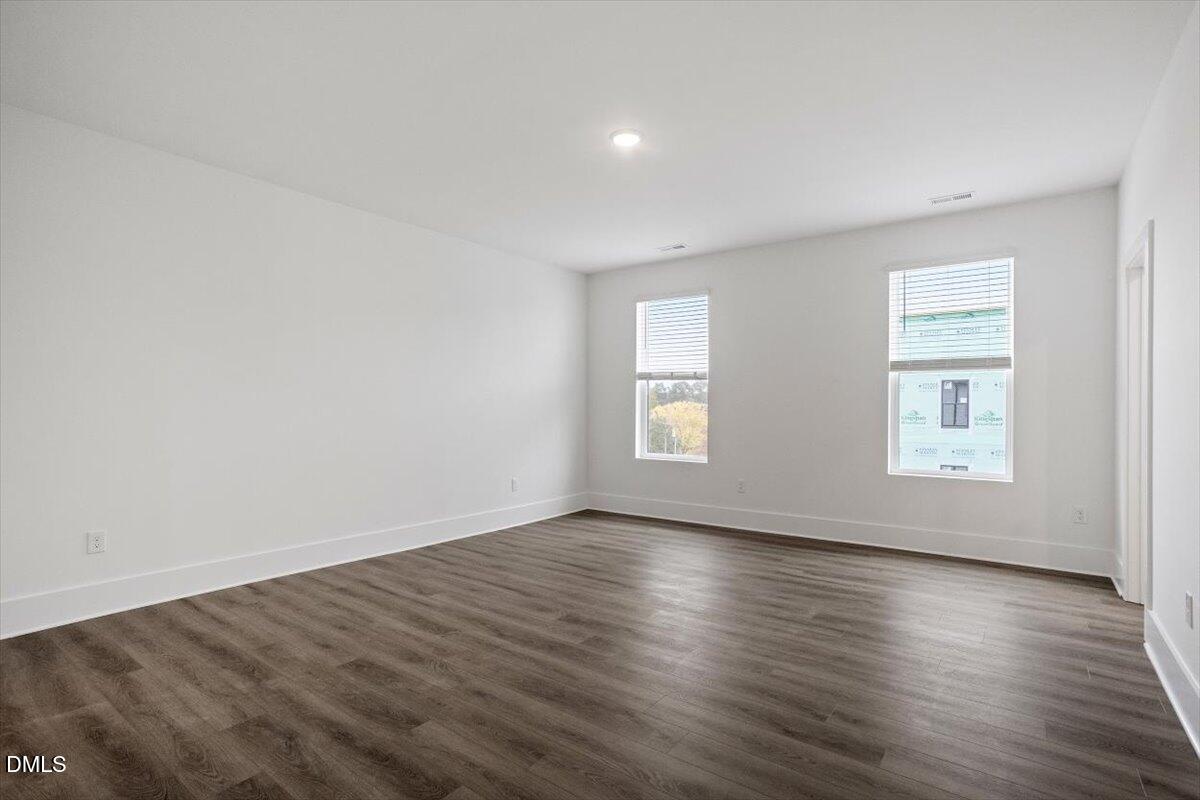 509 Kildaire Farm Road, Unit 302 Cary, NC 27511 - Photo 20 of 30 an empty room with wooden floor and windows
