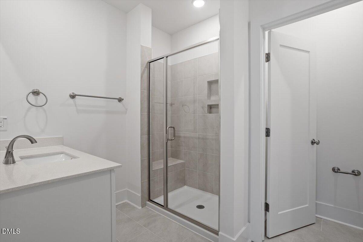 509 Kildaire Farm Road, Unit 302 Cary, NC 27511 - Photo 23 of 30 a bathroom with a shower sink and mirror