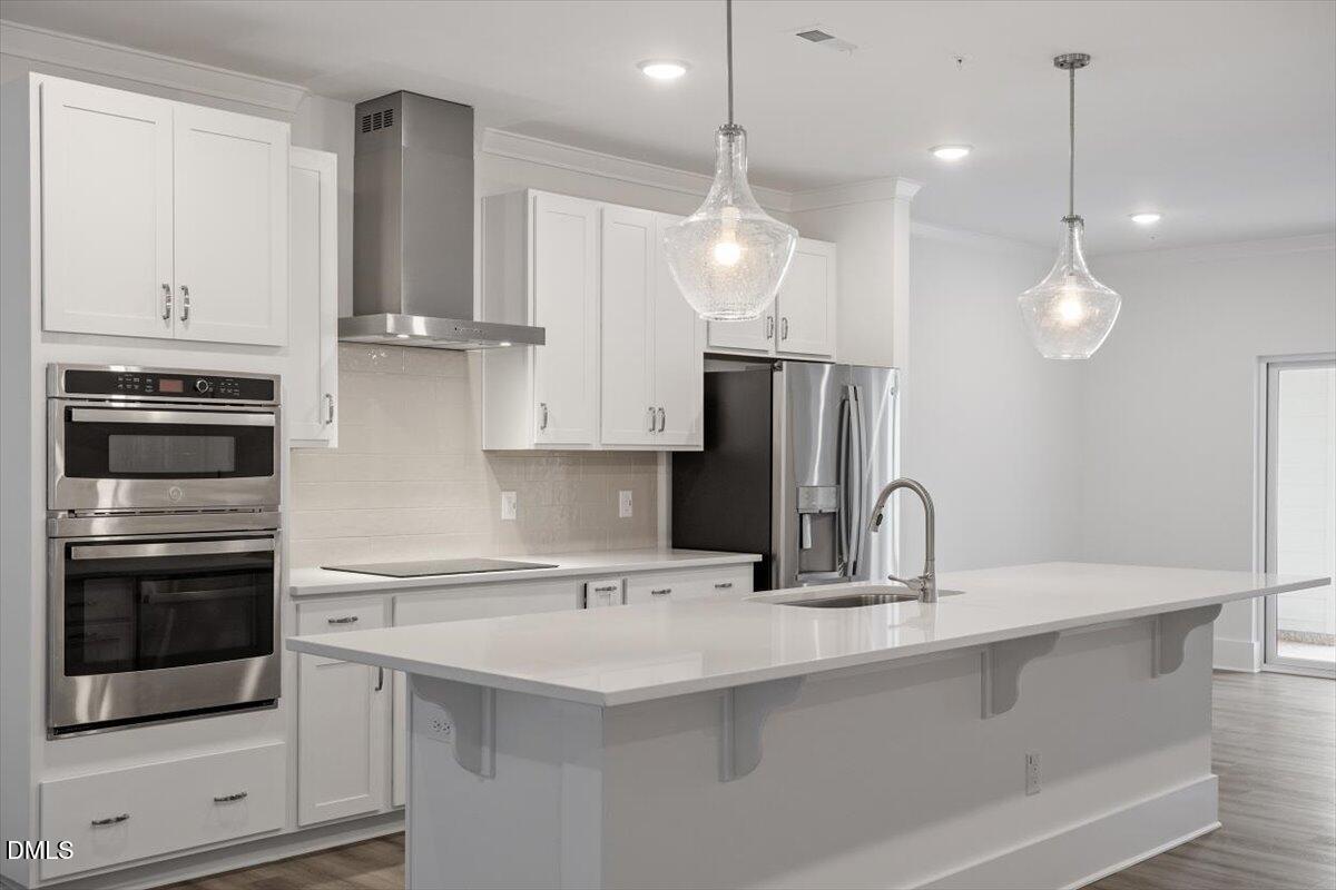 509 Kildaire Farm Road, Unit 302 Cary, NC 27511 - Photo 8 of 30 a kitchen with kitchen island a sink stainless steel appliances and cabinets