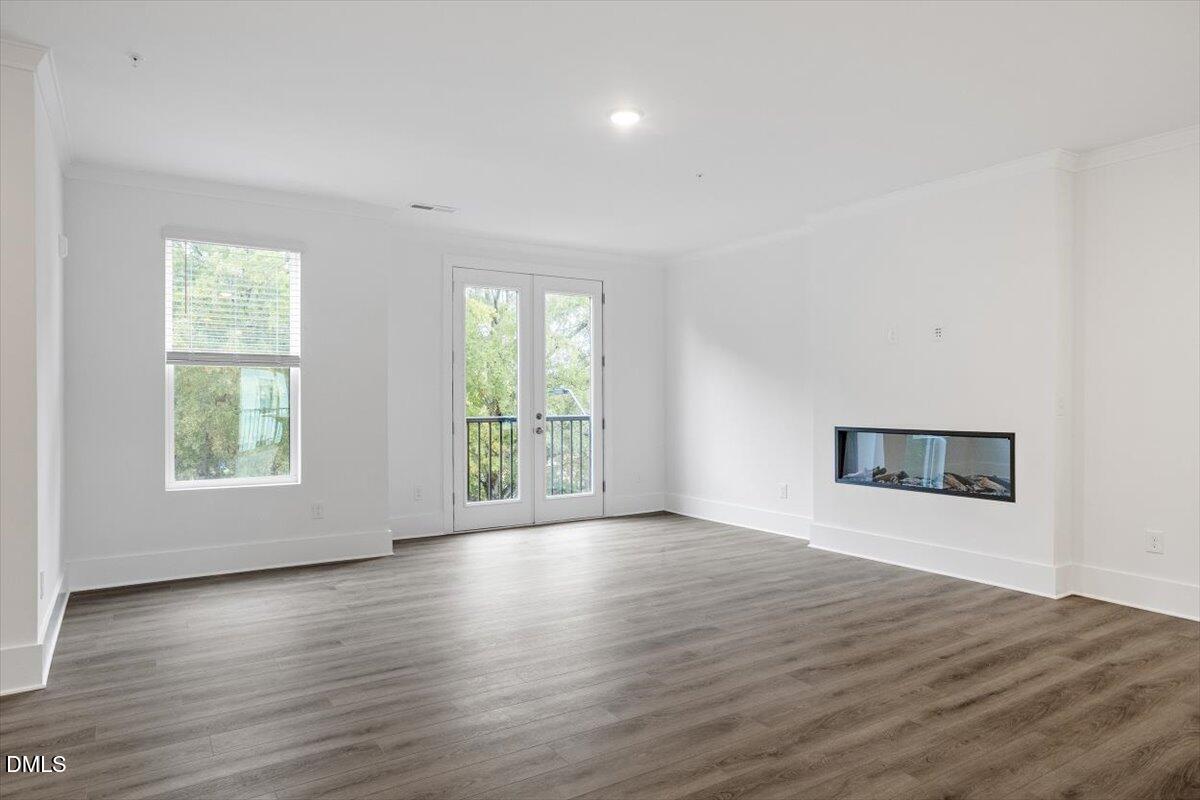 509 Kildaire Farm Road, Unit 302 Cary, NC 27511 - Photo 9 of 30 an empty room with wooden floor and windows
