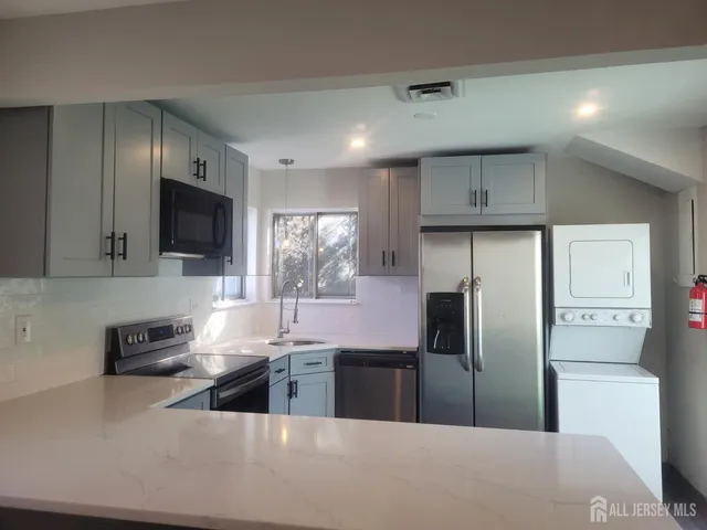 a kitchen with stainless steel appliances a refrigerator a sink a stove a microwave and cabinets