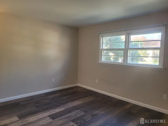a view of a room with wooden floor and windows