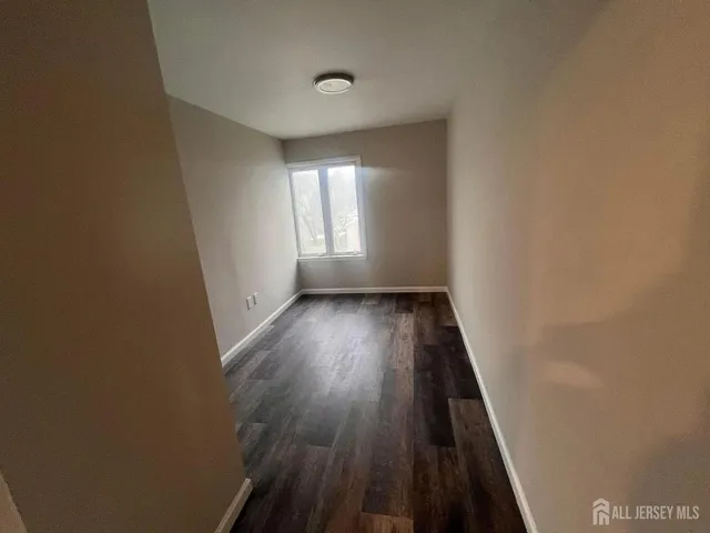 a view of a room with wooden floor and a window