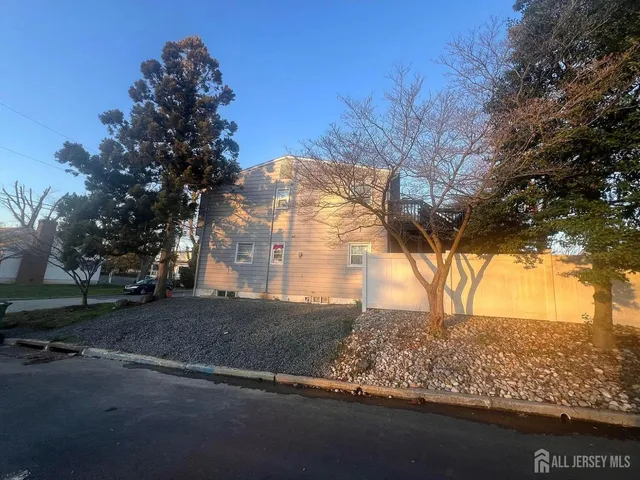 a view of a yard in front of a house with a large tree