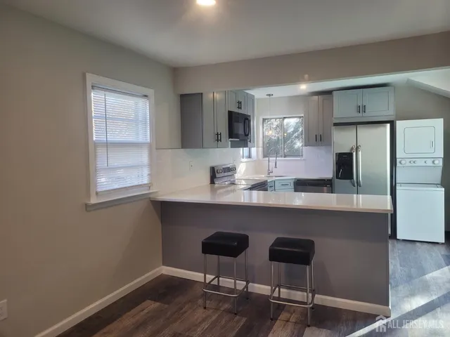 a kitchen with granite countertop white cabinets and stainless steel appliances