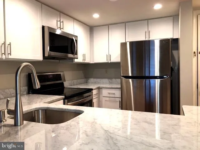 a kitchen with a refrigerator sink and wooden cabinets