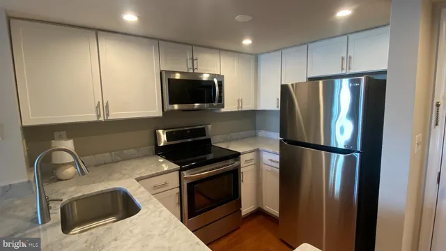 a kitchen with stainless steel appliances a refrigerator sink and microwave