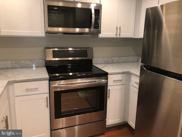 a stove top oven sitting inside of a kitchen