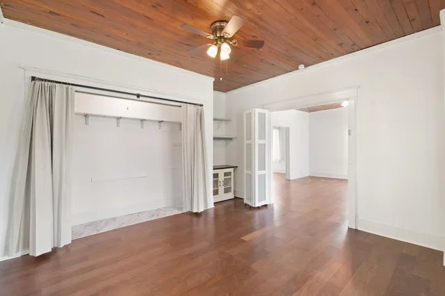 a view of an empty room with a ceiling fan window and a ceiling fan