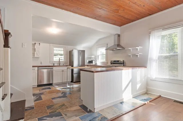 a kitchen with a refrigerator and white cabinets