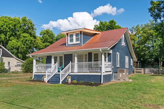 a view of a house with a yard and sitting area