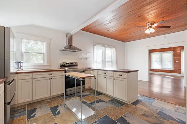 a kitchen with granite countertop stainless steel appliances a sink and cabinets