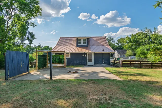 a backyard of a house with table and chairs