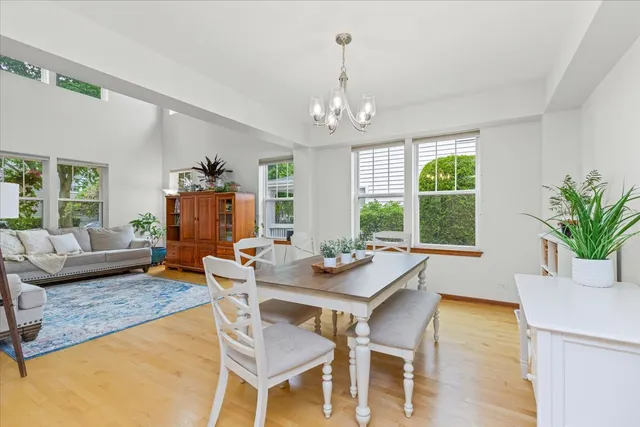 a dining room with furniture a chandelier and wooden floor