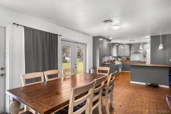 a living room with furniture kitchen view and a wooden floor