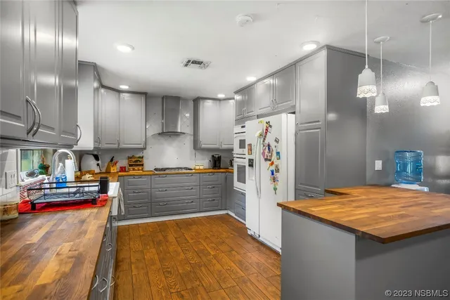 a kitchen with stainless steel appliances kitchen island granite countertop a refrigerator and a sink