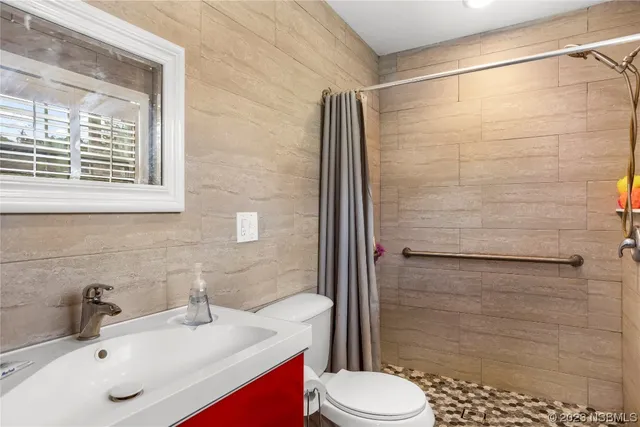 a bathroom with a sink a toilet and shower curtain