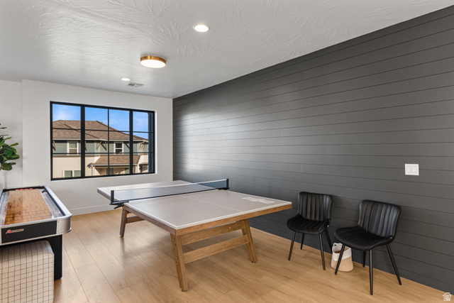 5367 Cyan Lane St. George, UT 84790 - Photo 23 of 49 Recreation room featuring a shiplap accent wall, large multi-pane window with black trim, recessed lighting, and wood-finish flooring